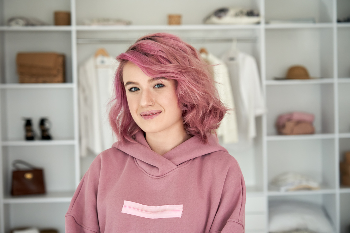 a person with pink hair wearing a pink sweatshirt