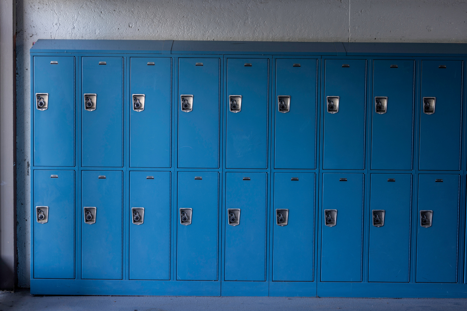 a row of blue lockers in an empty room
